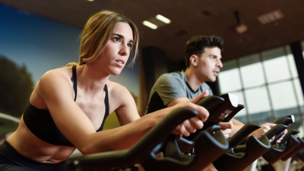 Imagens de pessoas praticando treino em bike spinning