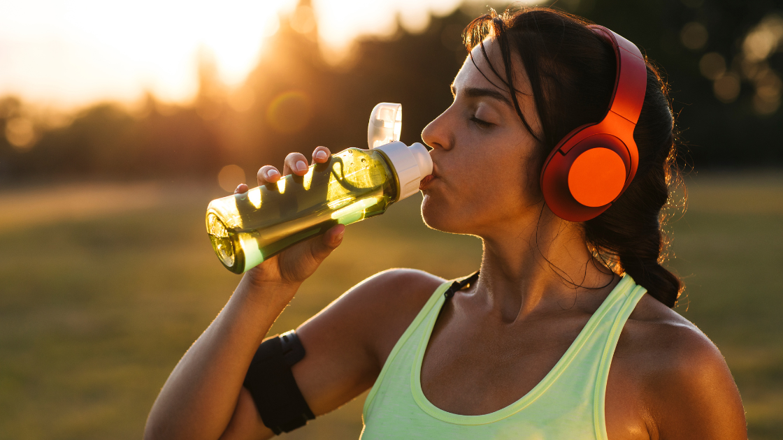 Mulher bebendo água durante o treino