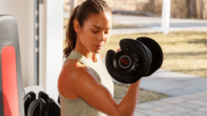 Mulher treinando força com halter Bowflex